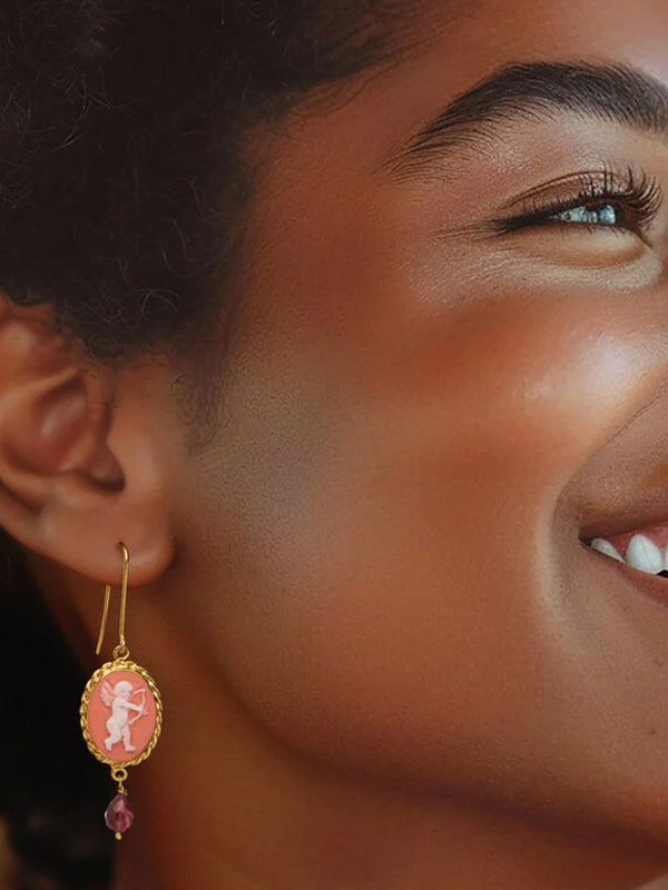 A girl wearing the pink Cupid cameo earrings with garnet