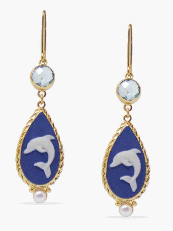 Dolphins cameo earrings by Vintouch are handcrafted from porcelain, showcasing swimming dolphins, symbolizing wisdom and salvation as per the Greek mythology, enriched with sparkling blue topaz.