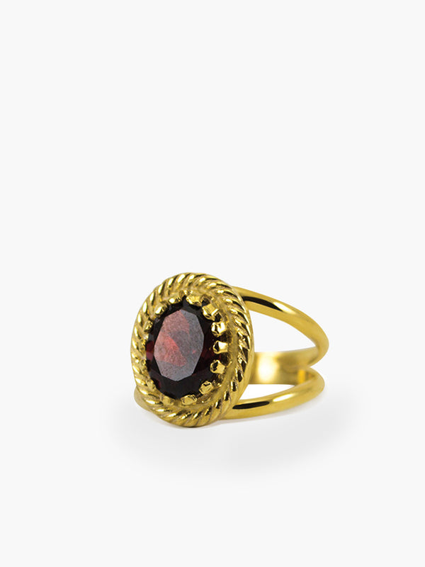 The Luccichio Garnet Stacking Ring by Vintouch Jewels features a gold-plated silver twisted band with a bold oval garnet, inspired by Italian studios—perfect for adding elegance to any jewelry collection.