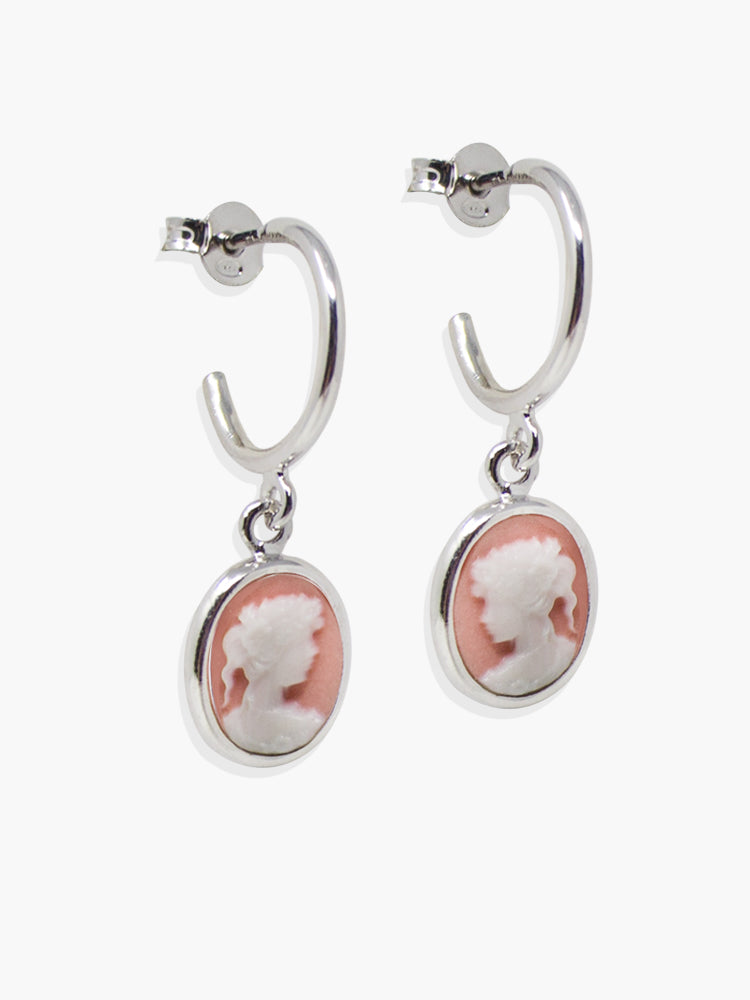 The Pink Mini Cameo Hoop Earrings by Vintouch Jewels are crafted in 925 sterling silver and feature oval pink and white handmade porcelain cameos with a classical female profile.