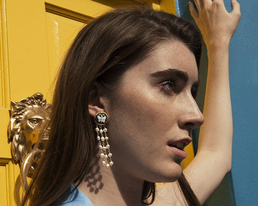 Woman wearing butterfly cameo earrings in gold-plated sterling silver with freshwater pearls, handcrafted in Italy