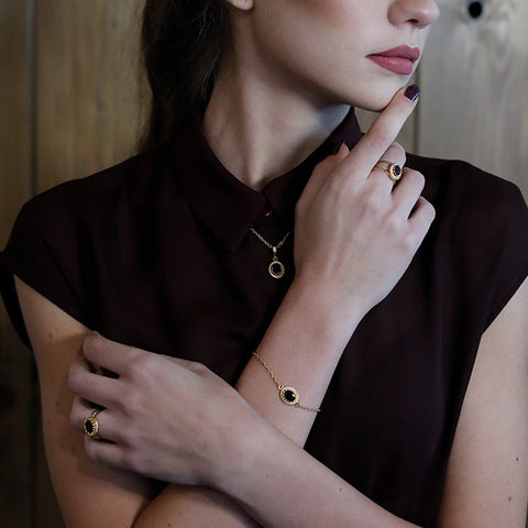 A brunette girl wearing a garnet bracelet. 