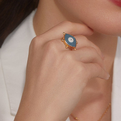 Woman wearing a blue porcelain evil eye ring in 18k gold-plated silver.