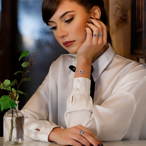 A young brunette girl sitting in a bar wearing sterling silver rings by Vintouch Jewels