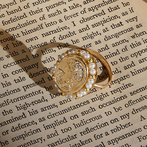 Gold Vermeil ring set with an array of lustrous freshwater pearls shot on an antique book