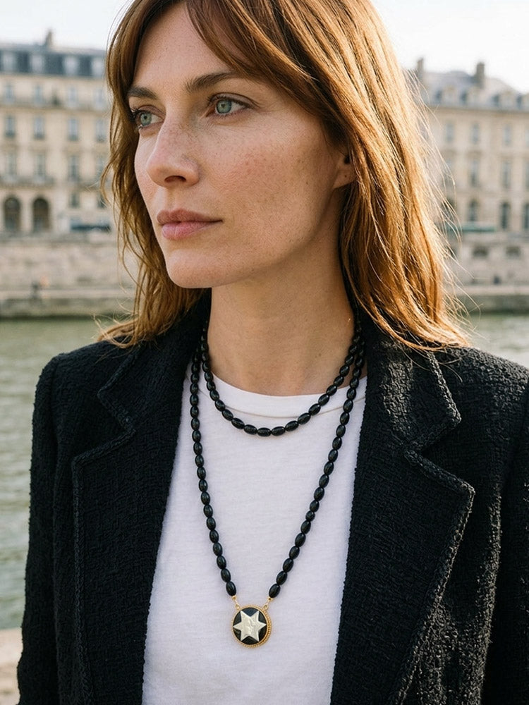 Woman wearing the long Star Dancer cameo necklace with black onyx beads in a double-layer style