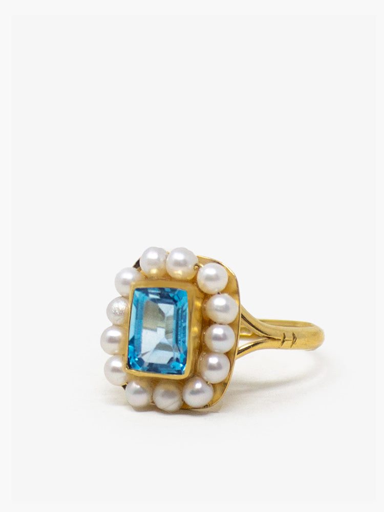 Handcrafted 18k gold-plated silver ring with natural blue topaz framed by hand-set freshwater pearls, inspired by Victorian elegance.